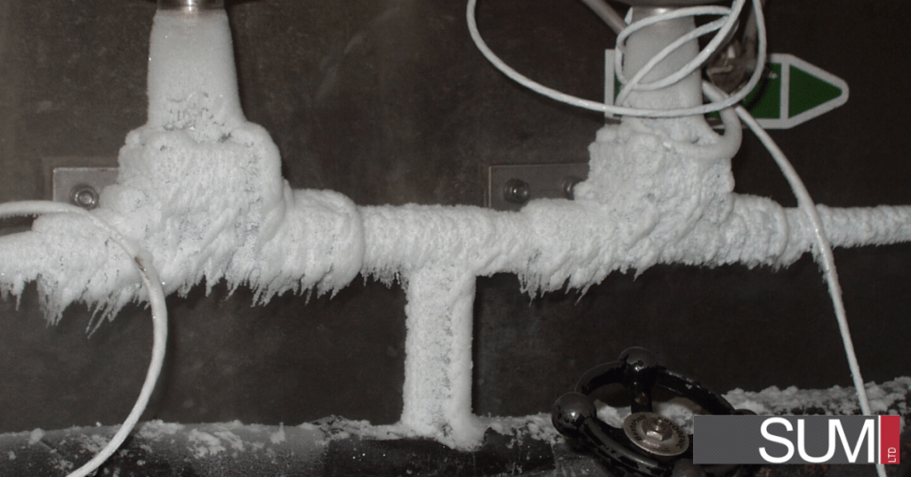 Winterize - Black and white photo of frozen pipes and valves.